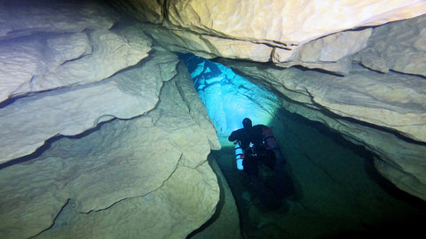 Diver dropping down into a chute at Ressel cave in France