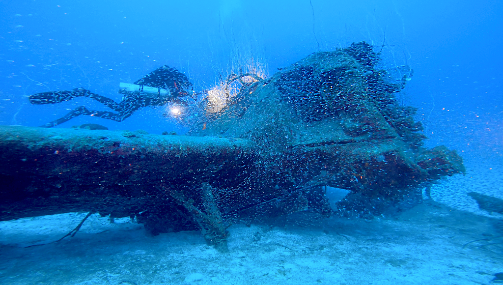 Divers above the wreck of a hellcat plane in Bikini Atoll