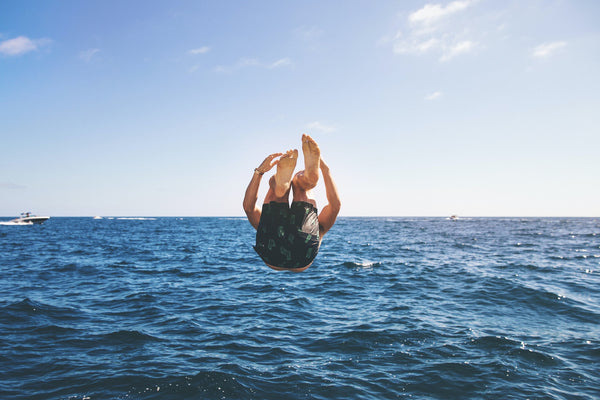 An action shot of a man diving into the ocean