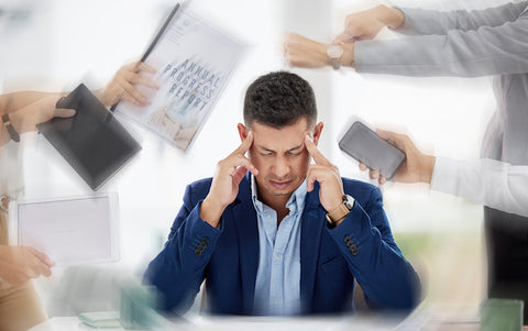 photo of man with stressors all around him in a blur; headache triggers concept