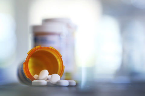 photo of antibiotic bottle on table laying on side with pills spilled out