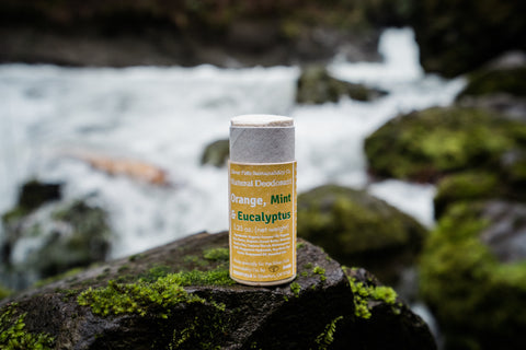 Natural deodorant on a rock in front of a river