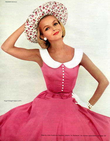 Girl in a pink dress and hat is sitting on the ground