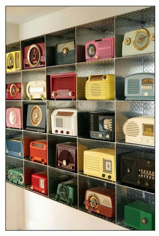 A shelf full of various bakelite radios in many shades of colours