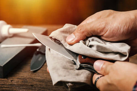 Man cleaning knife with cloth