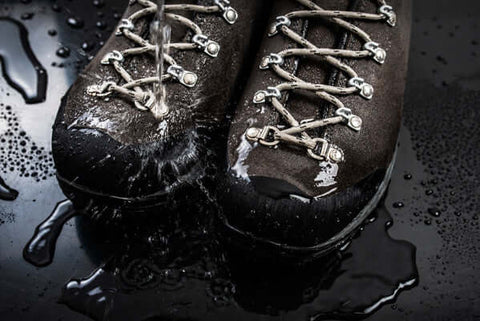 Water pouring onto a pair of boots