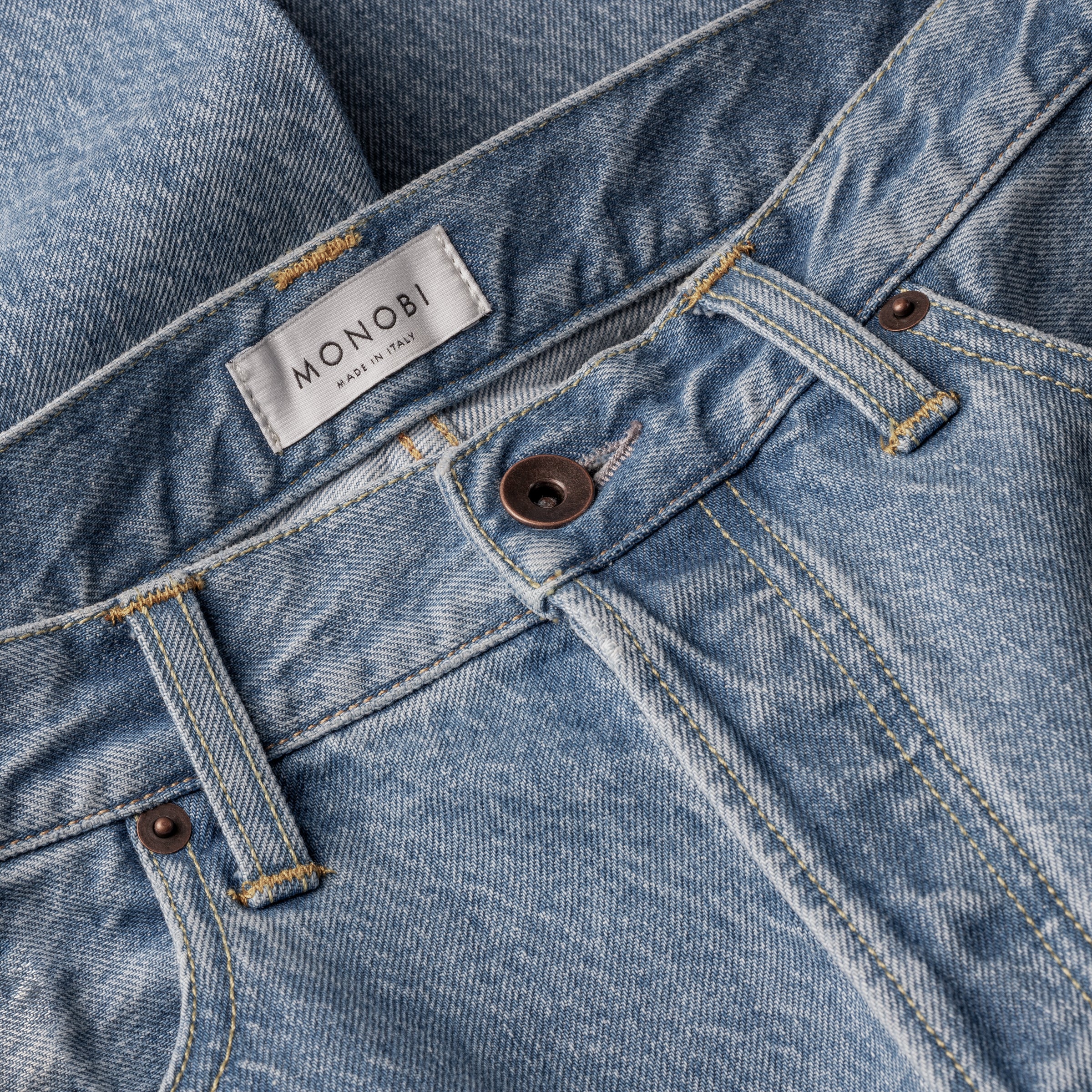 waist and button detail of the MONOBI denim trousers