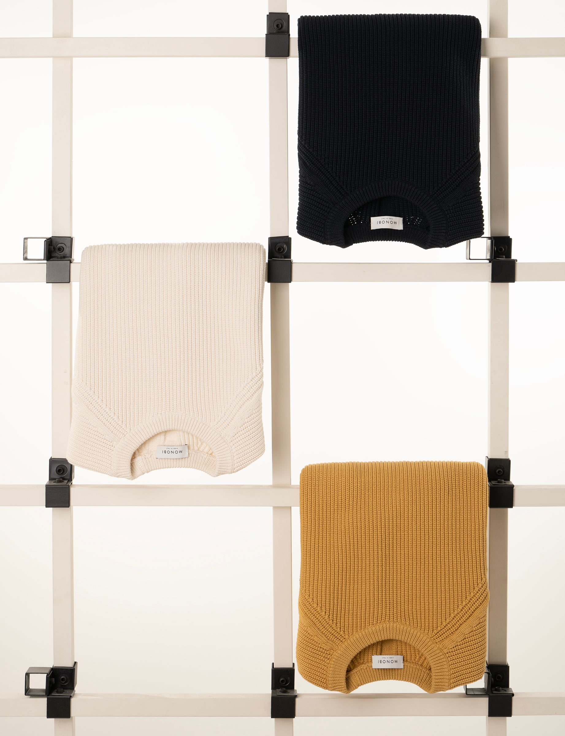 the three different colours of the pearlised long-sleeved model hanging in the wooden frame