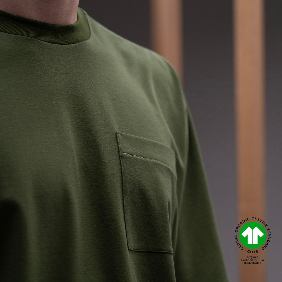 dettaglio della tasca della t-shirt verde con logo della certificazione GOTS del cotone