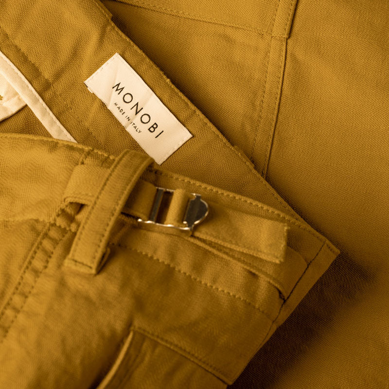 Detail of the MONOBI label on the ochre cargo pants