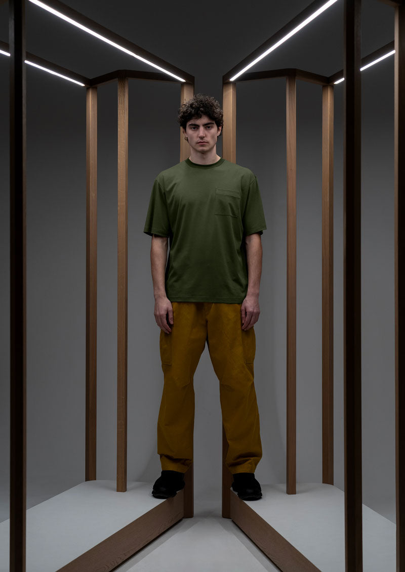 Model wearing ochre cargo pants and green t-shirt