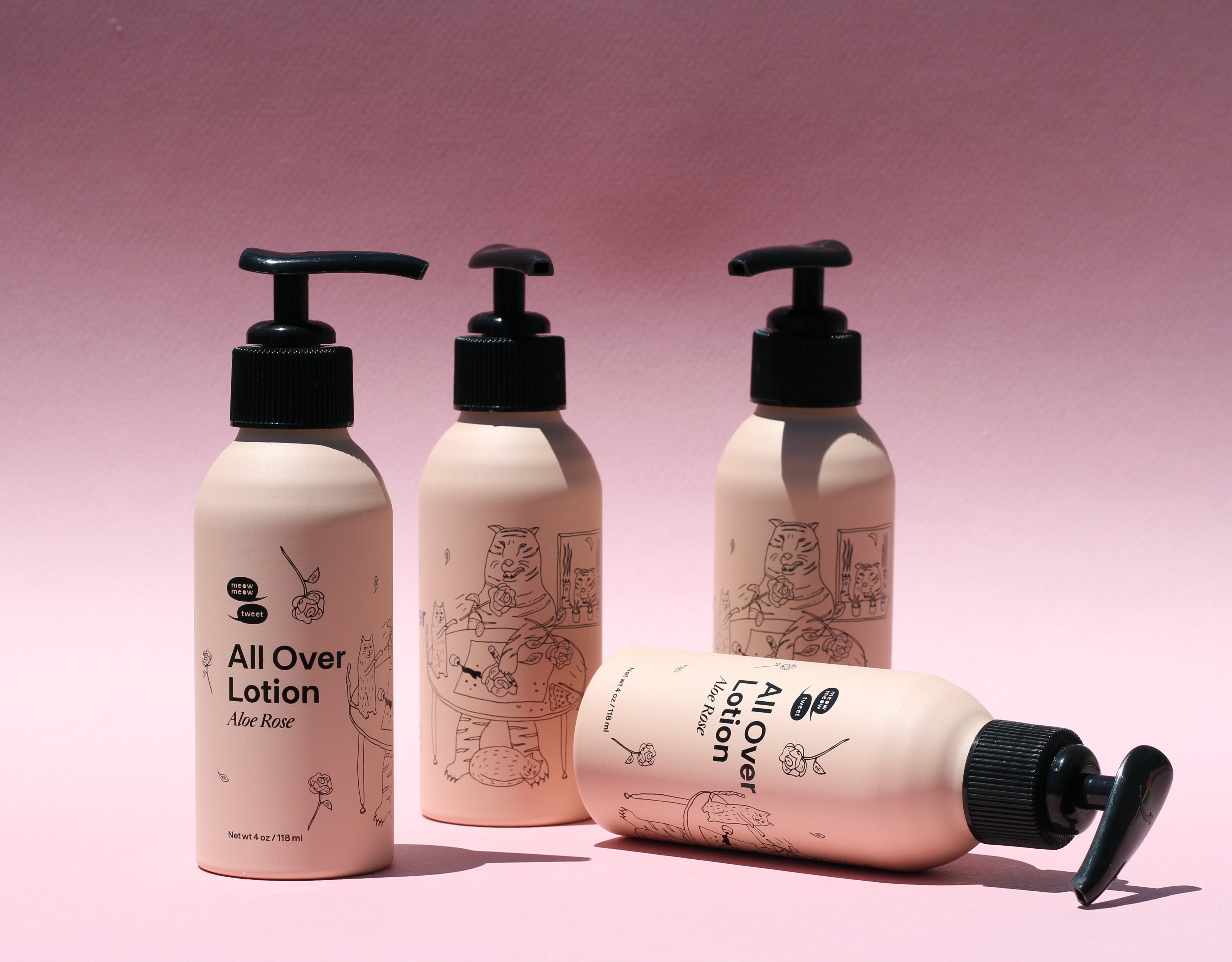 four light pink bottles with black text and graphics sit on a pink background