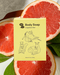 A yellow box of soap on a background of sliced pink grapefruit