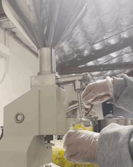 a gif of a bottle being filled in an assembly line
