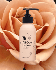 A bottle of Aloe Rose Lotion sits on a pink rose backdrop