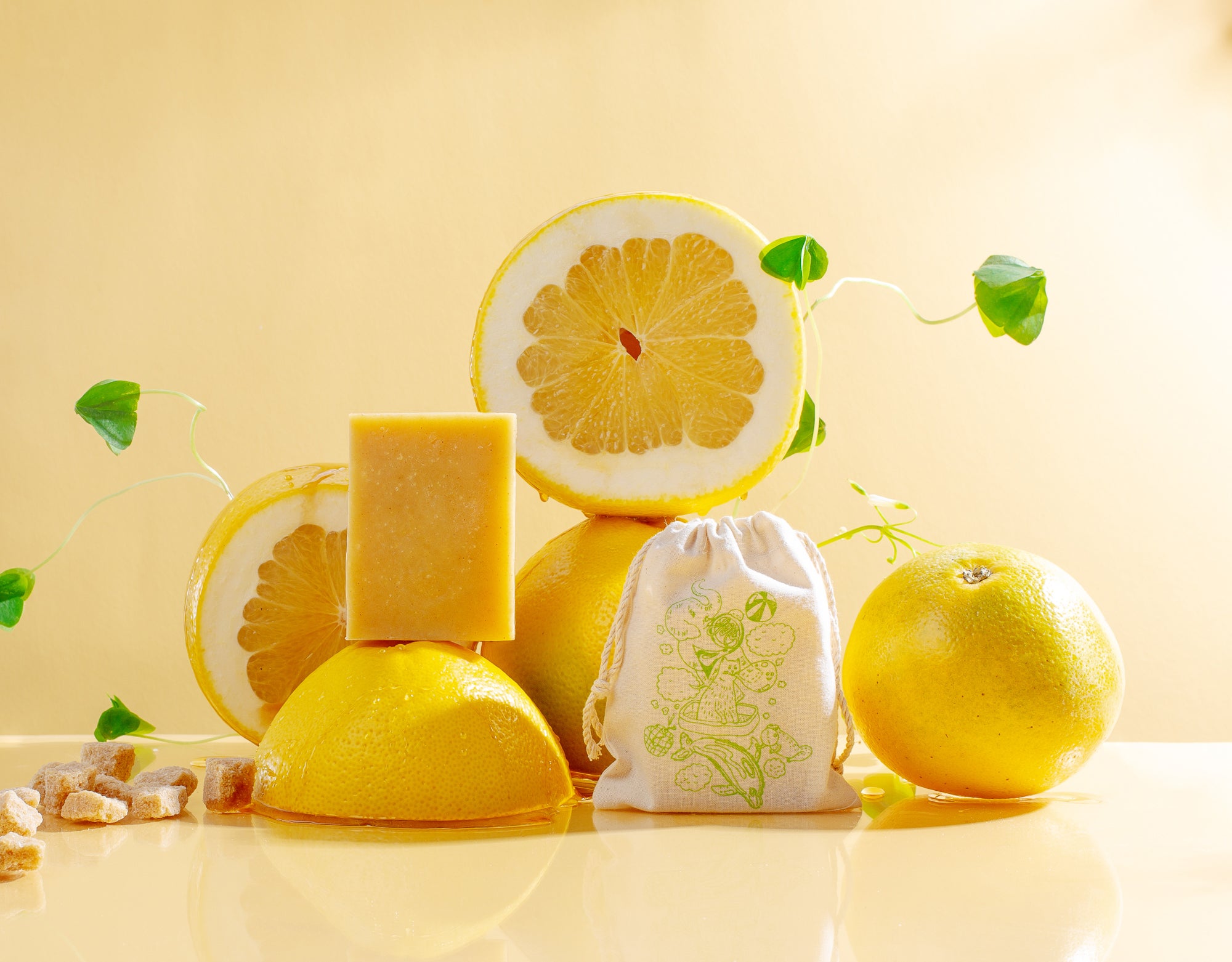 Yuzu Chamomile soap, yuzu slices, herbs sit on a sunny honey-yellow background