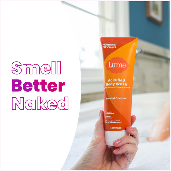 Woman taking a soapy bath holding a Lume toasted coconut scented acidified body wash, and the text: smell better naked
