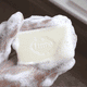 Hands lathering a bar of Lume soap