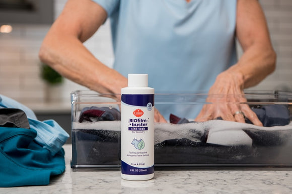 Person using sink soak to soak their clothes in a water basin