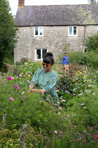 Sarah in her cutting garden in front of their country cottage, wearing Humphries and Begg Green Skydive dress