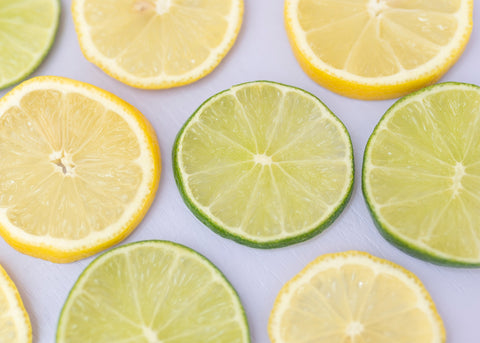 circular sliced lemons and lime on purple counter