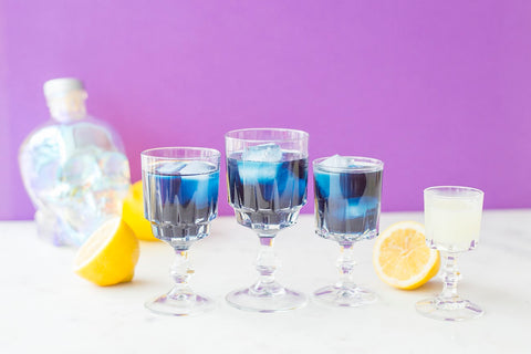 3 goblets filled with butterfly pea flower iced tea