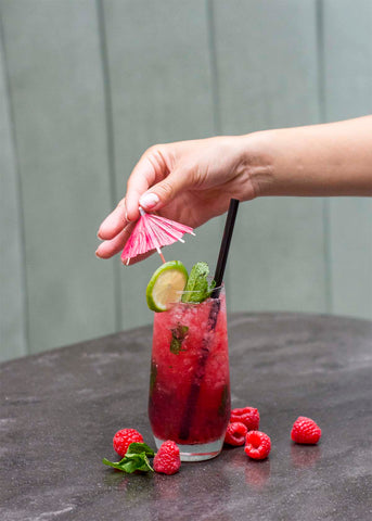 adding an umbrella to crimson berry mojito