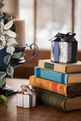 tea caddies wrapped in ribbon on book stack