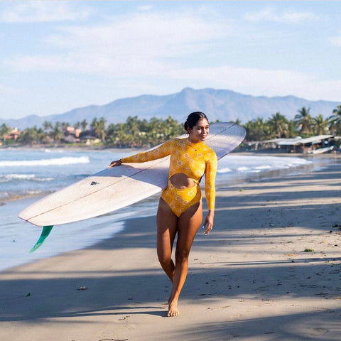 Surfer girl Patty in orange blossom rashguard suit at the beach