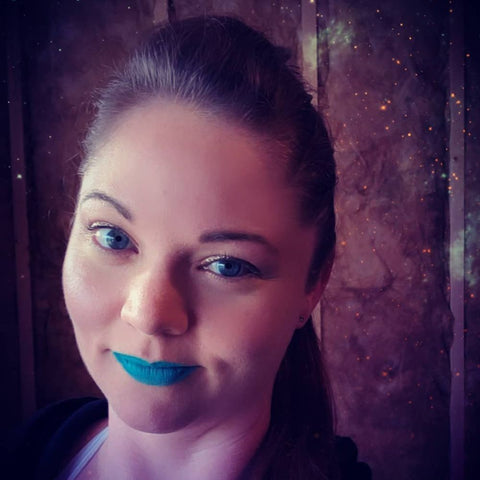 Close-up of a female face showing off simple eye make-up with blue lipstick.
