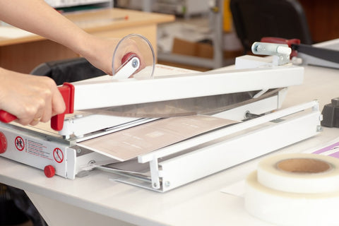 Guillotine paper cutter cutting through paper