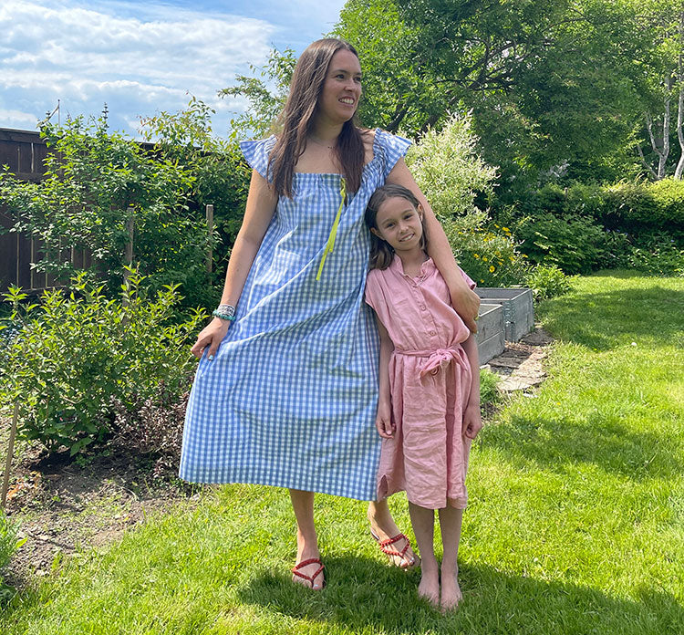 A woman in a garden wears a gingham nightie next to a girl wearing a pink linen dress