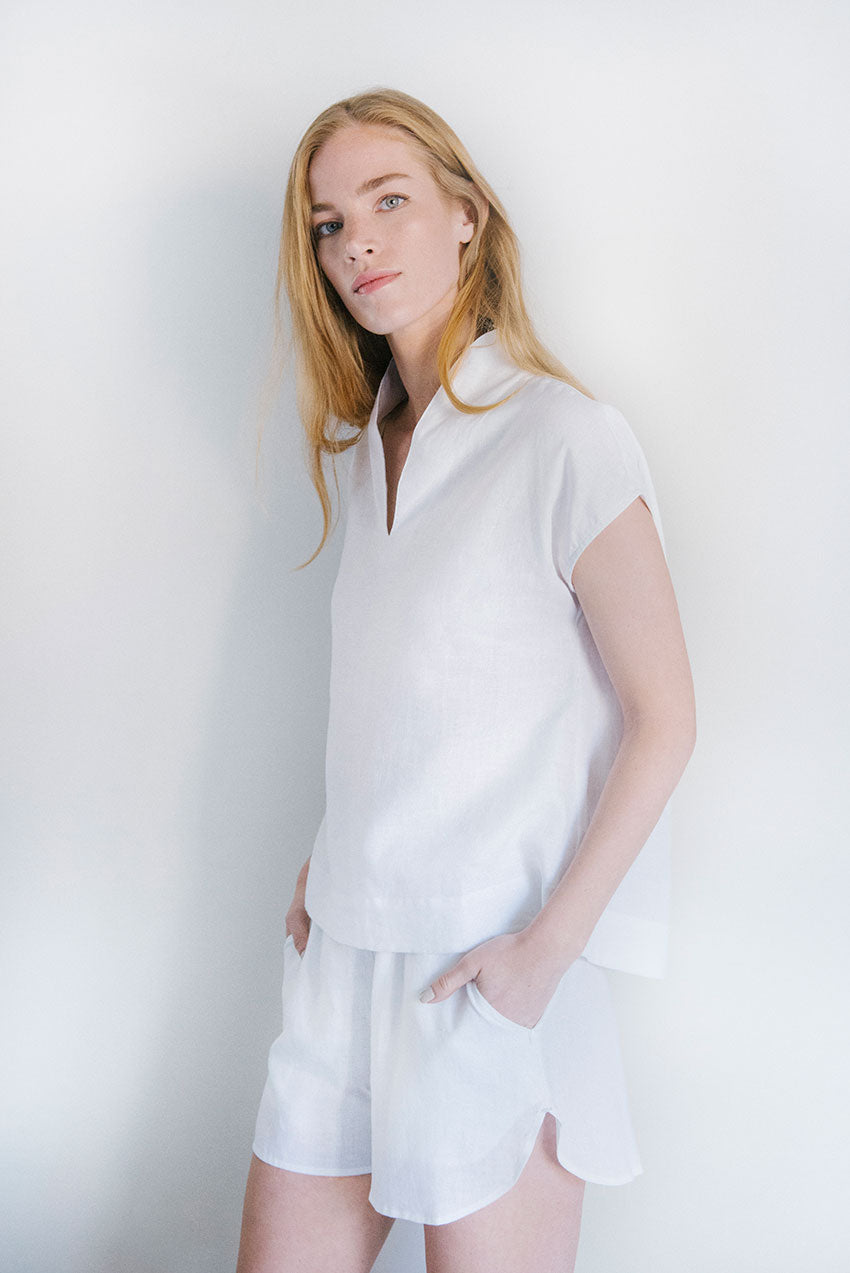Hands in pockets of the Curve Hem Shorts White Linen with matching Shawl Coller Top