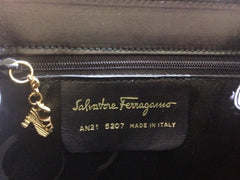 Vintage Salvatore Ferragamo black calf leather backpack with golden motif closure and shoe engraved motifs. Rare masterpiece.