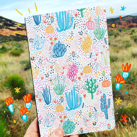 Denik notebook with repeat pattern of desert motifs photographed against a desert background.