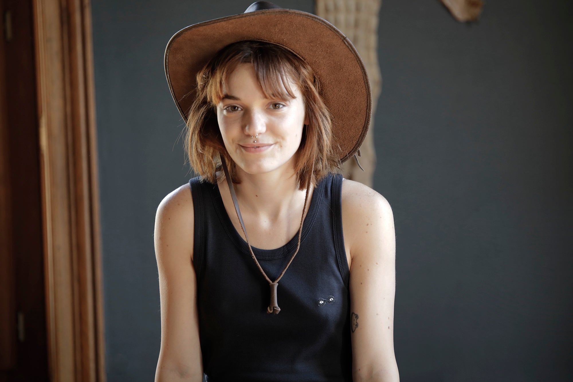 Femme en débardeur marcel blanc en coton côtelé et chapeau