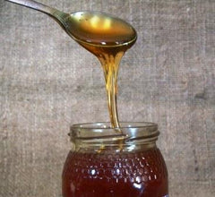 Raw organic honey on a spoon to show the colour and consistency