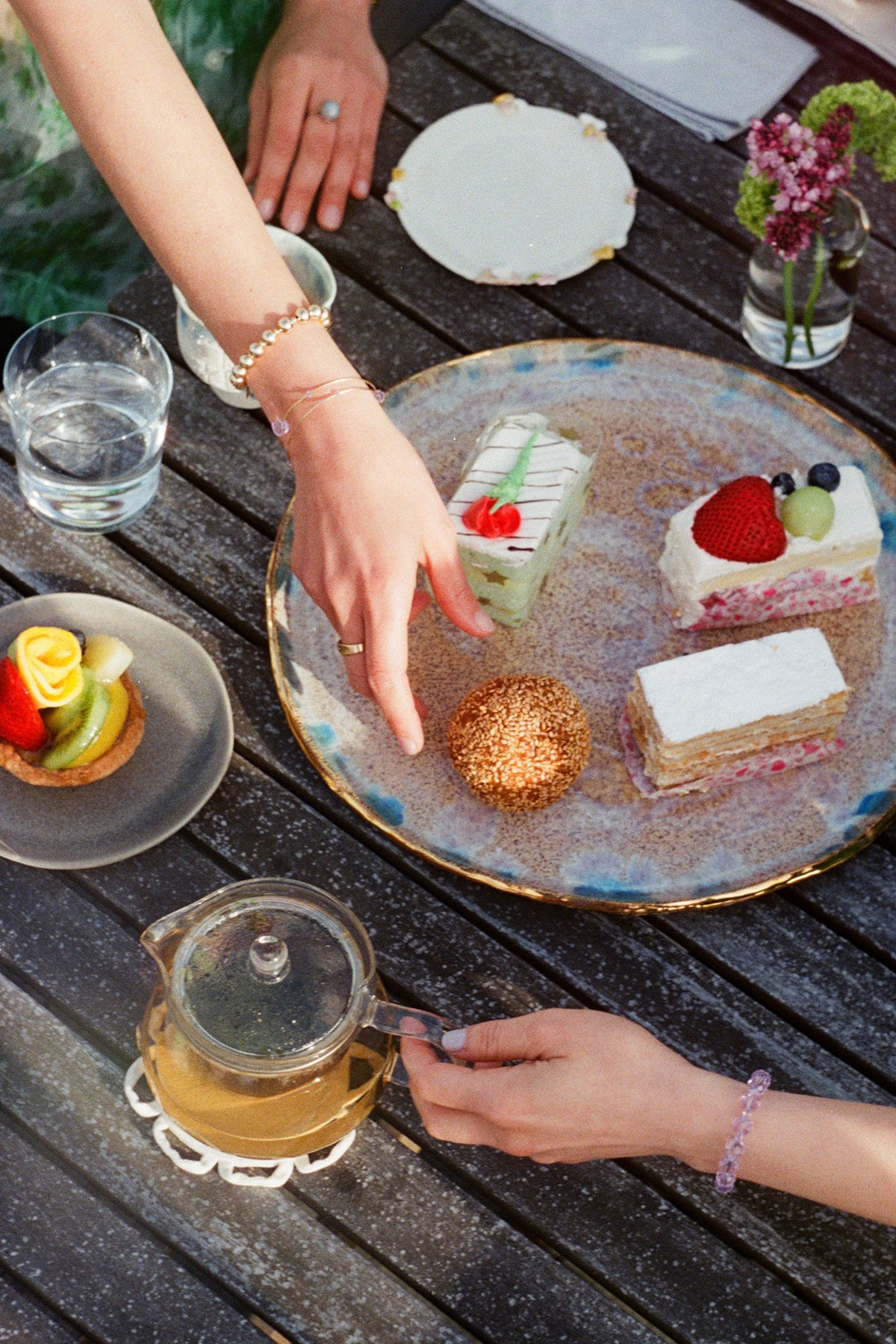 Hyacinth Collection image featuring Hyacinth Bracelet and Sprinkle Bracelet Set worn by two women enjoying tea time outside.