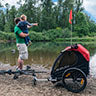 Dad stand with his child and a Burley bike trailer.