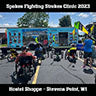Recumbent trikers watch Dan from Spokes Fighting Strokes give a clinic in front of his trailer.