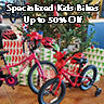 Two kids bike sit in front of a Christmas tree.  The text says, "Specialized kid's bikes up to 50% off."