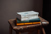 Pile of books and notebooks on wooden stool