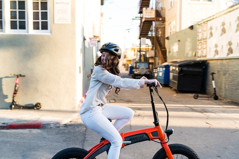 Girl riding an electric city bike in the city