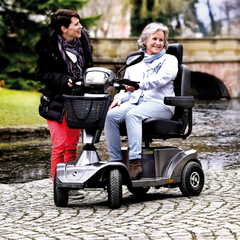 elderly woman smiling riding an electric mobility scooter