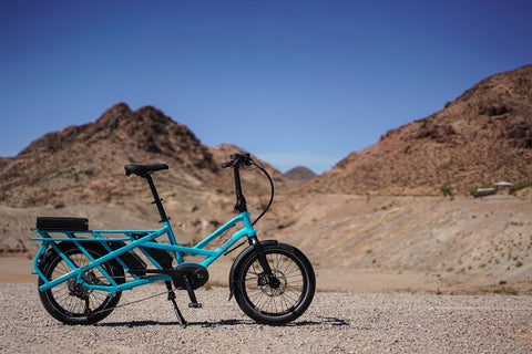 Light blue electric cargo bike in the middle of the desert