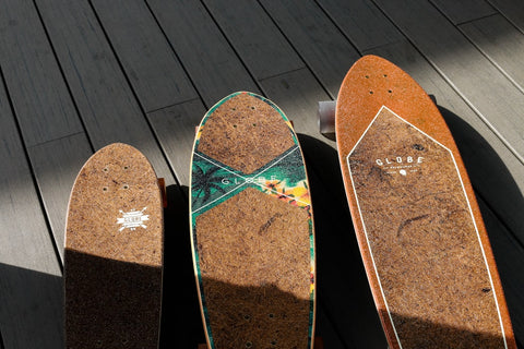 three brown electric skateboards on wooden floor