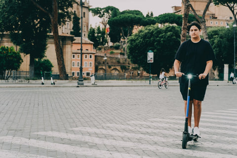 Man in black shirt riding an electric scooter in the park