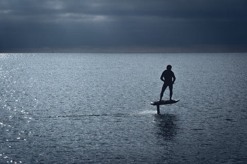 man riding electric foil board in the middle of the lake