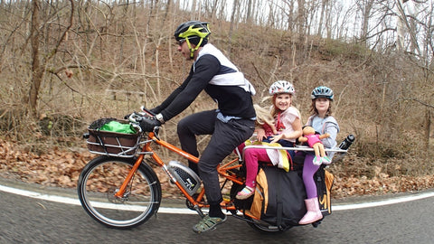 dad and his kids on a longtail cargo bike