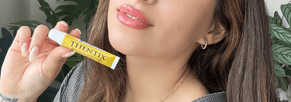 Thentix lip balm being held by a person with super soft and supple lips.